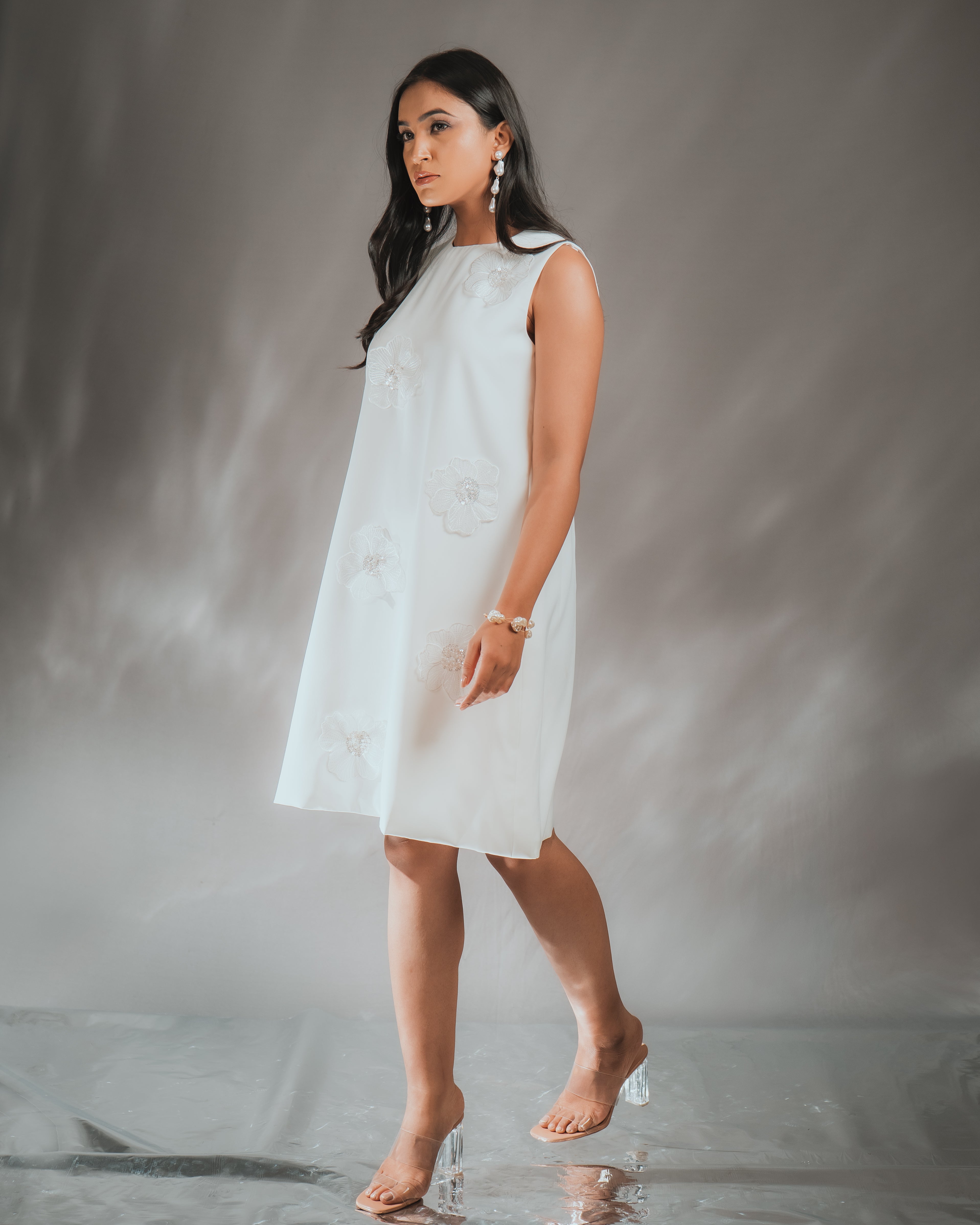 Model wearing a 3D FLOWER DRESS with sequined embroidery, showcasing the dress's elegant design.