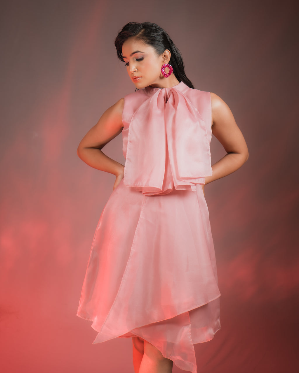 Model wearing ORGANZA BOW DRESS with elegant bow detailing, showcasing luxurious pink organza fabric.